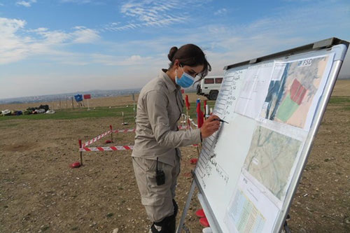 Noor, Team Leader of a clearance team, updates the board with the key information on the current task