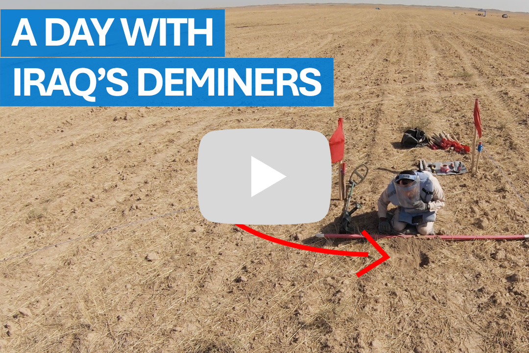 Deminers during their refresher training, observing a demonstration of manual clearance procedures